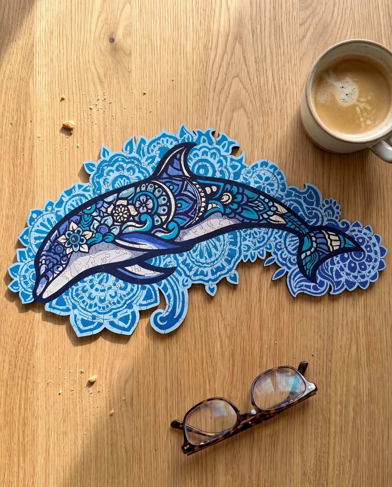 Puzzle Dauphin Majestueux terminé, posé à plat sur une table en bois au petit-déjeuner